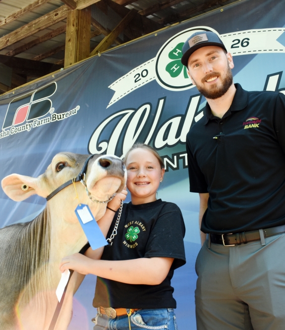 Scarlett Beltz of the West Albany Winners with a representative of buyer Foresight Bank.